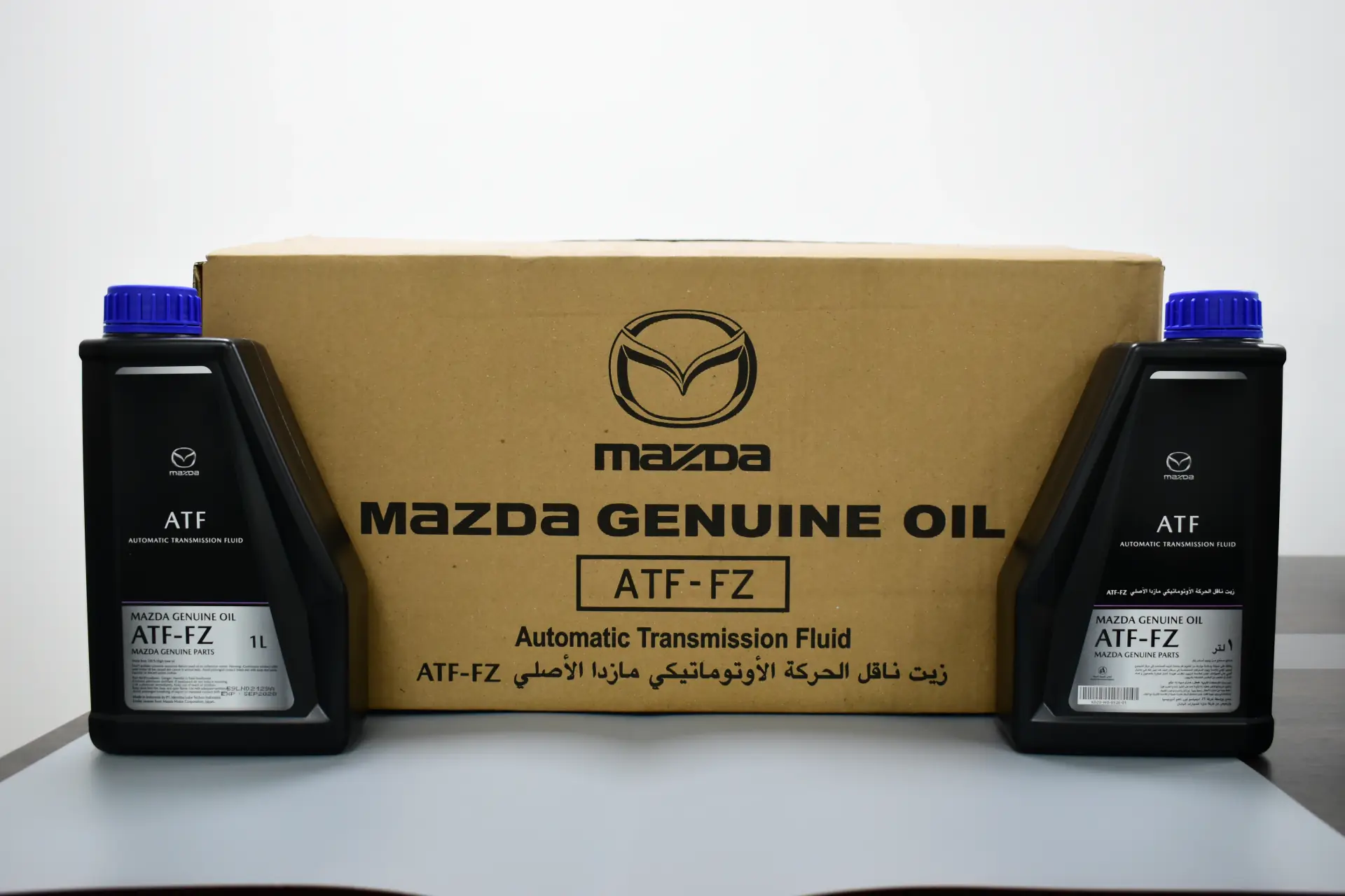 Two bottles of Mazda genuine ATF-FZ automatic transmission fluid beside their carton